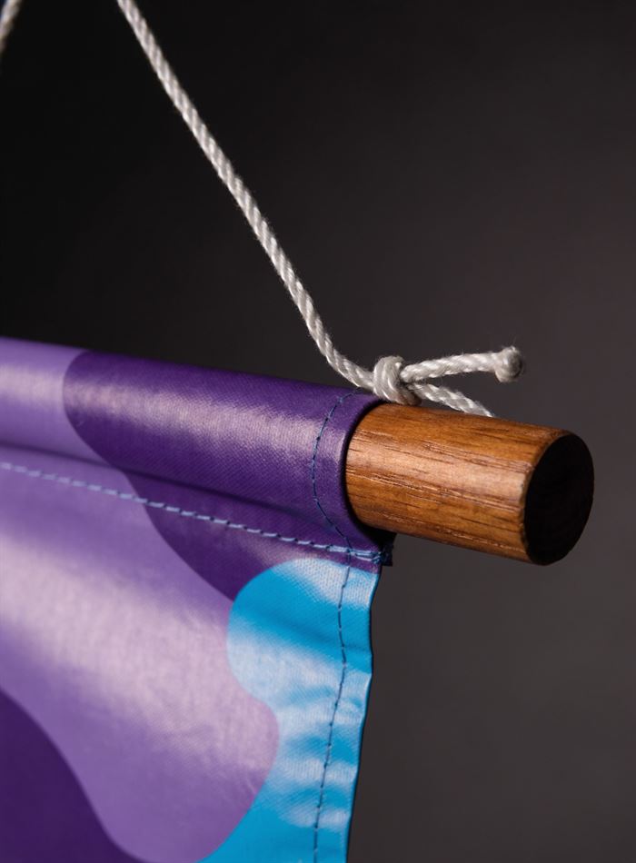 Banner acabado com bastão de madeira na bainha e corda para pendurar