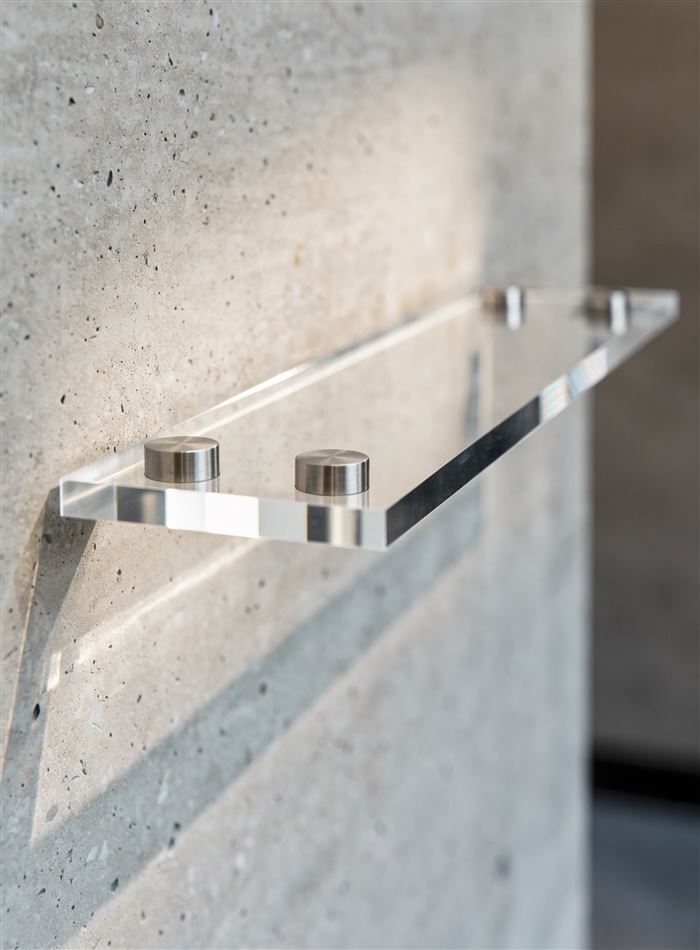 Placa de acrílico transparente fixada na parede com prolongadores de inox