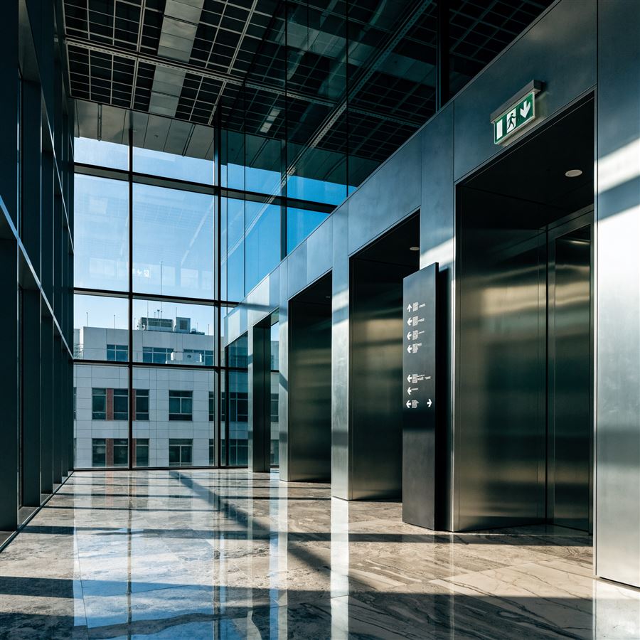 Hall de prédio comercial com painel de diretório e sinalização de saída